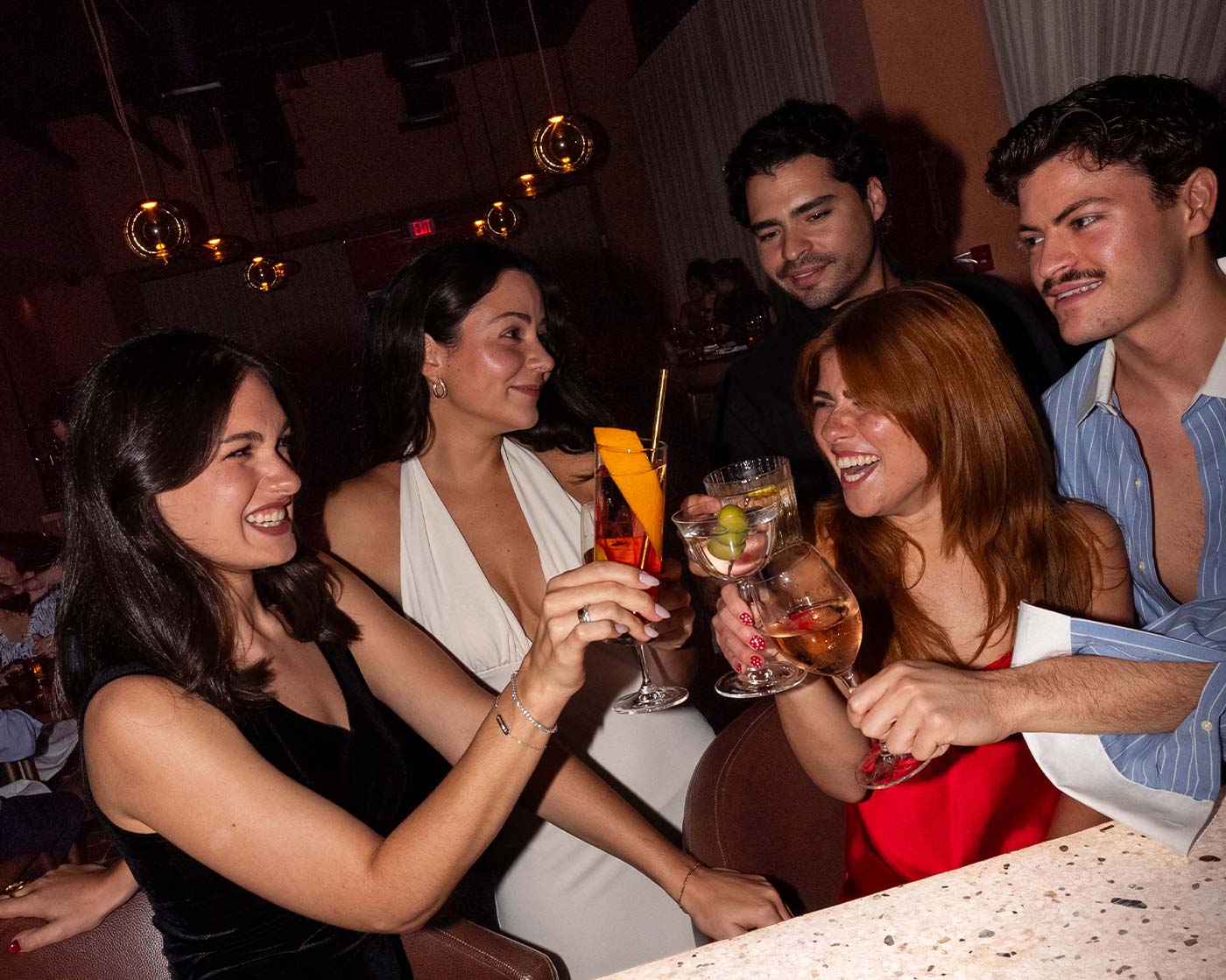 The table gathered — friends, pasta and a round of cocktails